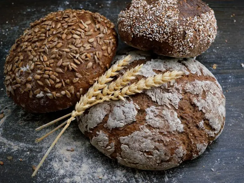 Seeded and rye loaves on a floured board